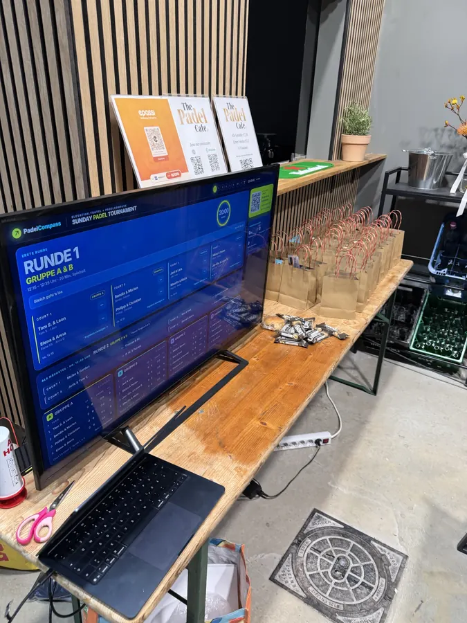 Turnierleitung: Laptop und TV mit dem Live-Spielplan, Runde 1