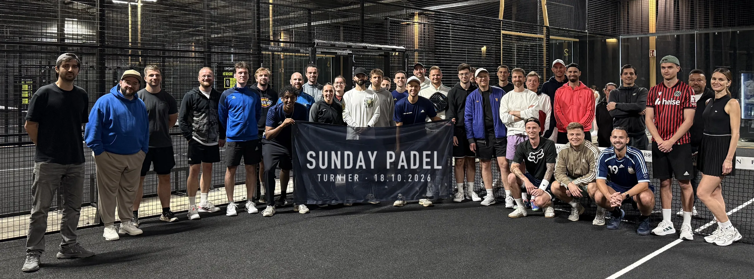 Gruppenfoto mit allen 32 Spielerinnen und Spielern auf dem Court, in der Mitte ein Banner mit der Aufschrift Sunday Padel, Turnier 18.10.2026